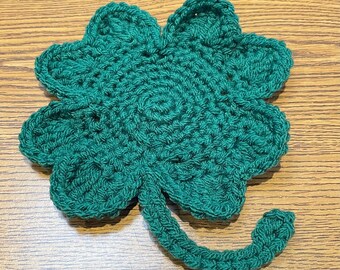 May include: A green crocheted four-leaf clover with a stem.