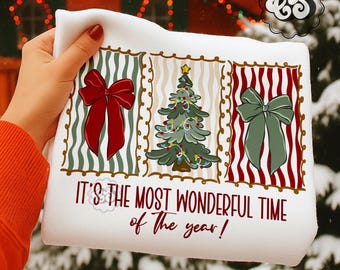 May include: White Christmas-themed sweatshirt with a festive design. It features three panels: two with bows and one with a decorated Christmas tree. The text "IT'S THE MOST WONDERFUL TIME of THE YEAR!" is printed below the panels.