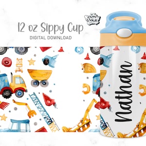 Puede incluir: Una taza para beber con boquilla personalizada de 350 ml con fondo blanco y un patr&oacute;n colorido de veh&iacute;culos de construcci&oacute;n, incluidos camiones, excavadoras y gr&uacute;as. El nombre "Nathan" est&aacute; impreso en negro en la taza.