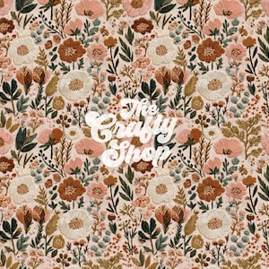 Pode incluir: Um tecido com um design de bordado floral completo. O design apresenta várias flores em tons de pêssego, castanho e creme, com folhas verdes sobre um fundo bege claro. O texto "The Crafty Shop" está no centro.