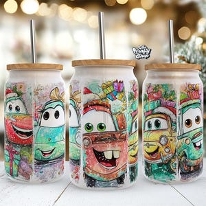 May include: Three glass tumblers with bamboo lids and stainless steel straws. Each tumbler features a colorful cartoon car design with Christmas elements. The cars are in red, blue, yellow, and green, with gifts and snow.