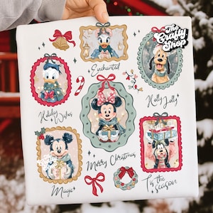 May include: A white square featuring festive Disney character illustrations in ornate frames. The design includes Donald Duck, Daisy Duck, Mickey Mouse, Minnie Mouse, and Goofy, with holiday-themed text like "Merry Christmas" and "Tis the season."