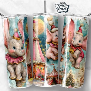 Puede incluir: Un juego de tres vasos de acero inoxidable de 590 ml cada uno, con temática de circo. Cada vaso presenta una ilustración de acuarela de un elefante bebé con grandes orejas, con un sombrero y un cuello festivos, sobre un fondo de una carpa de circo y una noche estrellada.