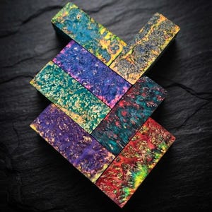 May include: A collection of six rectangular wooden blocks featuring stabilized burl wood with vibrant, multi-colored resin infusions. The blocks display swirling patterns of blue, purple, green, yellow, and red, showcasing a high-gloss finish.