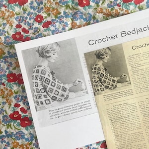 May include: A black and white photo of a woman wearing a crocheted bed jacket. The jacket is made of square motifs and has ribbed cuffs. The text "Crochet Bedjacket" is at the top of the image.
