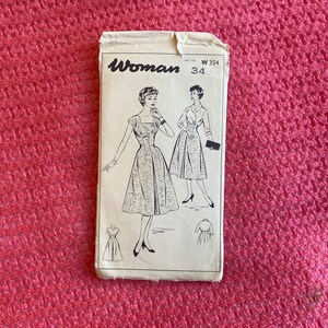 May include: Vintage sewing pattern for a dress, labelled "Woman" with the pattern number W354 size 34. The pattern shows two women wearing dresses with a similar style.