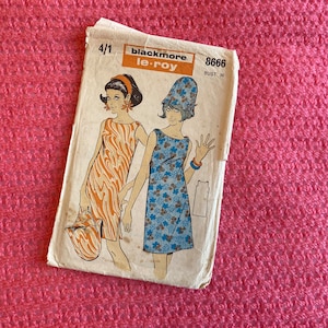 Op de afbeelding: Vintage naaipatroon voor een jurk, met twee modellen die jurken zonder mouwen dragen. Het patroon is gelabeld "Blackmore le-roy" en "8666" met een borstomvang van 91 cm. Het patroon is op een witte achtergrond met een lichtbruine rand.