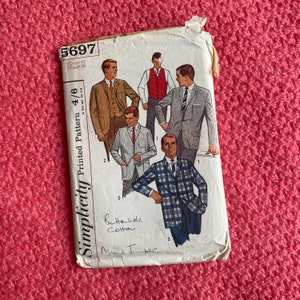 May include: A vintage Simplicity sewing pattern, number 5697, showing illustrations of men's suits and jackets. The pattern includes measurements for a 107 cm chest and a 97 cm waist. The pattern is printed on aged paper with handwritten notes.