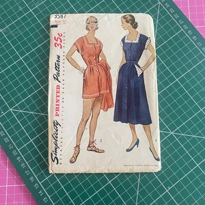 May include: Vintage Simplicity printed sewing pattern with two dress designs illustrated on the cover. The dresses are shown in orange and navy blue. The pattern number is 3587, and the price is 35c.