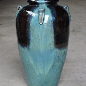 May include: A large, blue and black glazed ceramic vase with two handles. The vase is 42 cm tall and 68 cm wide and weighs 30 kg.