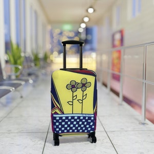 May include: A yellow, blue and red suitcase with a chequered pattern and two stylised flowers on the front. The suitcase has a black handle and wheels.