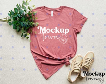 May include: A mauve colored t-shirt with the text "Mockup Town" and a camera graphic. The shirt is laying on a white surface with white polka dots.
