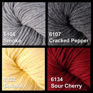 May include: Four skeins of yarn in different colors: gray, cracked pepper, banana, and sour cherry. The yarn is labeled with the color name and a number.