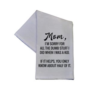 May include: A white kitchen towel featuring black text that reads: Mom, I'M SORRY FOR ALL THE DUMB STUFF I DID WHEN I WAS A KID. IF IT HELPS, YOU ONLY KNOW ABOUT HALF OF IT. The towel is folded, displaying the printed message clearly on the front surface.