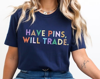 May include: A navy blue t-shirt with the text "HAVE PINS, WILL TRADE." in rainbow colors.