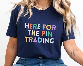 May include: A navy blue t-shirt with the text "HERE FOR THE PIN TRADING" in rainbow colors.