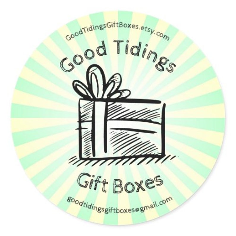 May include: A round sticker with a light green and white striped background. The sticker features a hand-drawn illustration of a gift box with a bow. The words "Good Tidings" and "Gift Boxes" are written in a handwritten font.