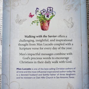 May include: The back cover of a book with the title "Walking with the Savior". It features a watercolor illustration of a flower pot with purple and white flowers and butterflies. The text describes the book's content.