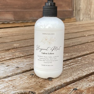 May include: A white bottle of Bergamot Mint Tallow Lotion with a black pump top. The label reads "Simple Elegance" and lists the ingredients: Water, Tallow, Jojoba Oil, Emulsifying Wax, Steric Acid, Optiphen Plus (natural preservative), Essential Oils. The bottle is made in the USA.