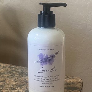 May include: A white bottle with a black pump top and a label that reads "Simple Elegance Lavender". The label also lists the ingredients: water, tallow, jojoba oil, emulsifying wax, stearic acid, optiphen plus (natural preservative), and essential oils. The bottle is made in the USA.