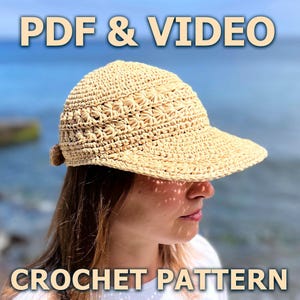 Può includere: Un cappello da sole beige all'uncinetto con tesa e motivo decorativo. Il cappello è indossato da una persona, con il testo "PDF & VIDEO" e "CROCHET PATTERN" nell'immagine.