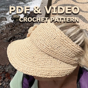 Op de afbeelding: Een close-up van een beige gehaakte zonnehoed met een brede rand. De hoed wordt gedragen door een persoon met blond haar. De tekst "PDF & VIDEO CROCHET PATTERN" wordt boven de hoed weergegeven.