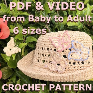 Pode incluir: Um chapéu de crochê bege com aba larga, adornado com três aplicações de borboletas rosa e azuis. O chapéu está sobre um fundo de folhas verdes e flores rosas. O texto na imagem diz "PDF & VIDEO from Baby to Adult 6 sizes CROCHET PATTERN."