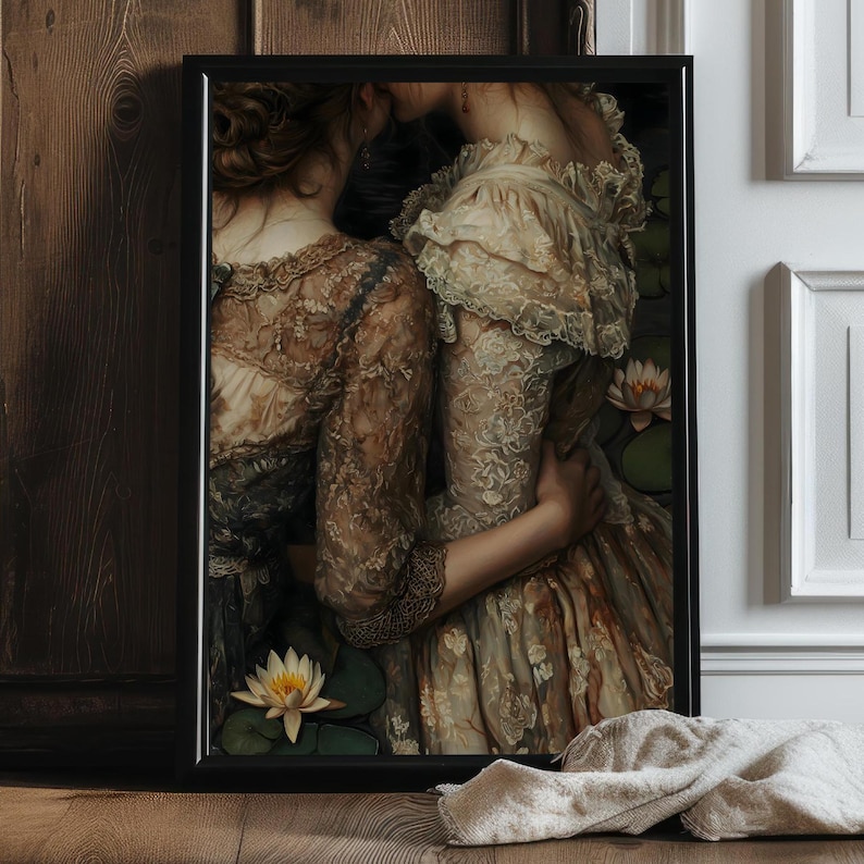 Puede incluir: Dos mujeres con vestidos de estilo vintage con detalles de encaje se abrazan en un exuberante jard&iacute;n. Las mujeres est&aacute;n rodeadas de vegetaci&oacute;n y nen&uacute;fares, creando una atm&oacute;sfera rom&aacute;ntica y et&eacute;rea.