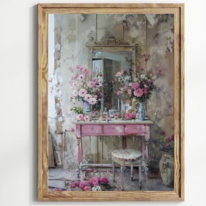 K&ouml;nnte beinhalten: Ein Vintage-Schminktisch-Set mit rosafarbener Lackierung. Der Schminktisch hat drei Schubladen und einen Spiegel mit einem verzierten Rahmen. Der Schminktisch ist mit rosa Blumen und einer Vase dekoriert. Der Schminktisch steht vor einem Hintergrund einer hellgrauen Wand mit einem abgenutzten Look.