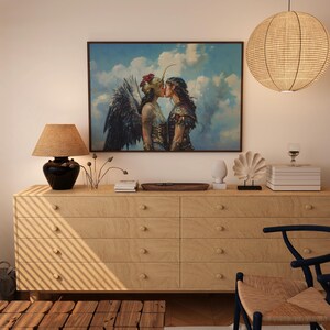 May include: A painting of two figures kissing in front of a cloudy sky. The figures are wearing elaborate costumes and appear to be mythical creatures. The painting is framed and hanging on a wall above a wooden dresser.