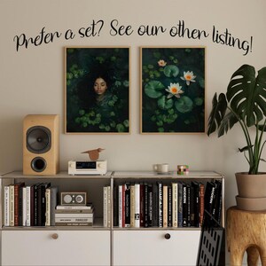 May include: Two framed prints, one with a woman submerged in a pond with lily pads and the other with white water lilies on a pond. The prints are hanging on a wall above a shelf with books and a small stereo.