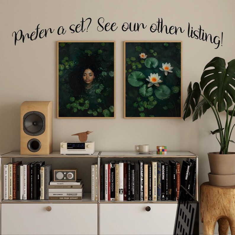 May include: Two framed prints, one with a woman submerged in a pond with lily pads and the other with white water lilies on a pond. The prints are hanging on a wall above a shelf with books and a small stereo.