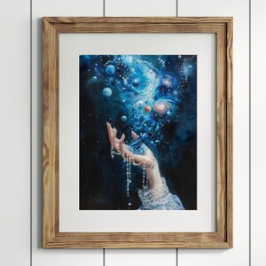 K&ouml;nnte beinhalten: Eine Hand mit einer Perlenkette greift nach einem wirbelnden blauen Nebel mit Sternen und Planeten. Die Hand tr&auml;gt eine wei&szlig;e Spitzen&auml;rmel.