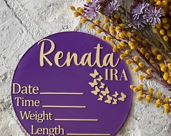 May include: Purple round acrylic sign with gold lettering and butterfly accents. The sign reads "Renata IRA" and has spaces to fill in the date, time, weight, and length.