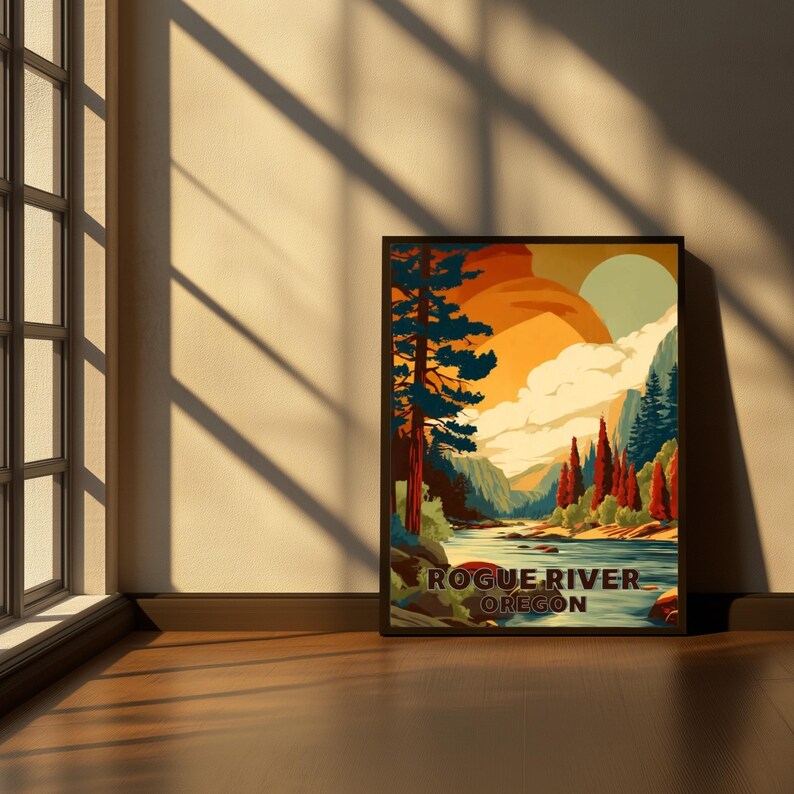 May include: A framed art print featuring a landscape scene with a river, mountains, and trees. The artwork has a vintage travel poster style, with warm colors like orange, yellow, and red. The text "Rogue River Oregon" is displayed at the bottom.