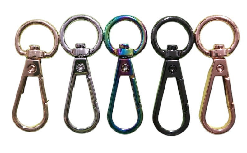 Pu&ograve; includere: Cinque chiusure girevoli in metallo in diverse finiture: oro, argento, arcobaleno, nero e oro rosa. Ogni chiusura ha un'apertura rotonda e un gancio.