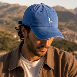 Puede incluir: Gorra de béisbol azul con visera curva y correa ajustable. La gorra presenta un pequeño bordado de llama en la parte delantera. El sombrero está hecho de un material suave, adecuado para uso casual.
