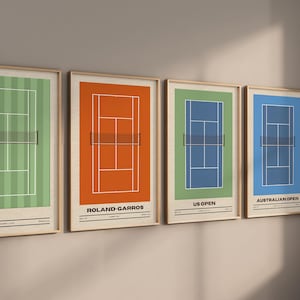 May include: A set of four framed wall art prints depicting tennis courts in different colors. The prints feature white court lines, a black net, and text labels including Roland-Garros, US Open, and Australian Open in a clean, minimalist layout.