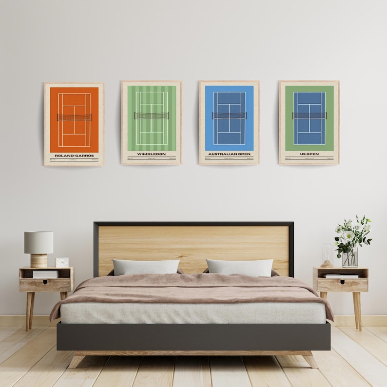 May include: Four framed prints of tennis courts, each with a different color and representing a different Grand Slam tournament: Roland-Garros (orange), Wimbledon (green), Australian Open (blue), and US Open (green). The prints are hanging on a white wall above a wooden bed frame.