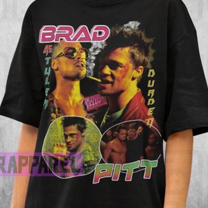 Könnte beinhalten: Schwarzes T-Shirt mit einer Grafik von Brad Pitt aus dem Film Fight Club. Das Design enthält den Text "Brad Pitt" und andere filmbezogene Texte. Das Model trägt ein 2XL-Shirt.
