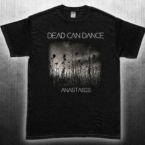 Könnte beinhalten: Schwarzes T-Shirt mit dem Bandnamen "Dead Can Dance" in Weiß, über einem Graustufenbild hoher Pflanzen. Das Wort "Anastasis" ist darunter gedruckt. Das T-Shirt hat kurze Ärmel und einen Rundhalsausschnitt.