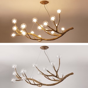 May include: A gold-toned chandelier with a unique branch-like design. The chandelier features multiple clear glass globes that hang from the branches. The chandelier is suspended from the ceiling by a chain.