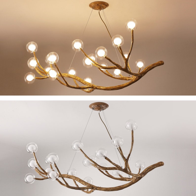 May include: A gold-toned chandelier with a unique branch-like design. The chandelier features multiple clear glass globes that hang from the branches. The chandelier is suspended from the ceiling by a chain.