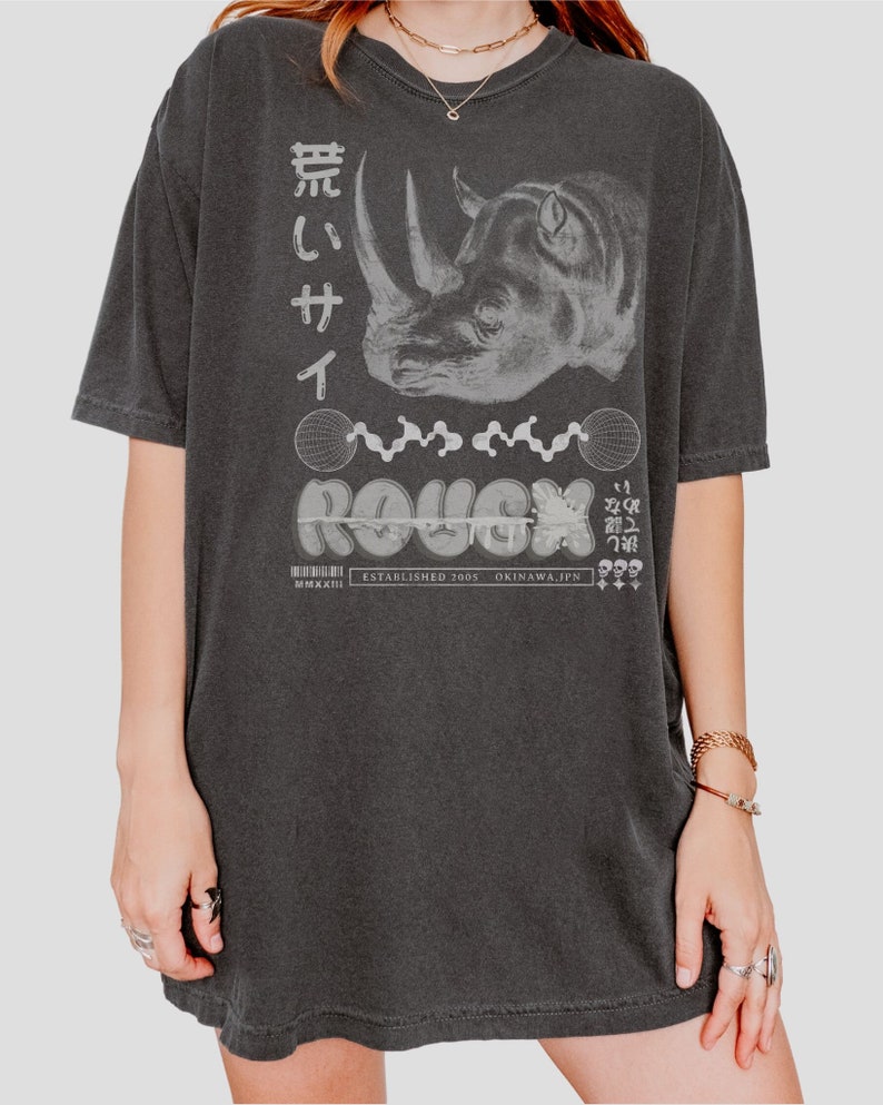May include: A black oversized t-shirt with a graphic print of a rhinoceros, the word "ROUGH" in a stylized font, and Japanese text. The text "ESTABLISHED 2005 OKINAWA, JPN" is also printed on the shirt.