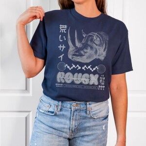 May include: A navy blue t-shirt with a white graphic of a rhinoceros and the text "ROUGH" in a stylized font. The text "ESTABLISHED 1963 OKINAWA, JPN" is also printed on the shirt.