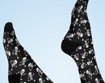 May include: Black socks with a repeating pattern of white skeleton figures. The socks are knee-high and have black heels and toes. The background is a light blue gradient.