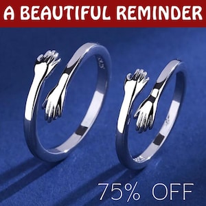 May include: Two silver rings with open bands, each featuring a pair of hands embracing. The rings are displayed on a blue background. The text "A BEAUTIFUL REMINDER" is at the top. The text "75% OFF" is at the bottom.