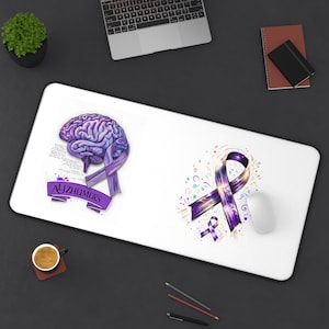 Może przedstawiać: Biała prostokątna podkładka na biurko z dwoma wzorami związanymi ze świadomością choroby Alzheimera. Jedna strona przedstawia fioletową grafikę mózgu z wstążką i napisem "Alzheimer's". Druga strona ma fioletowy wzór wstążki z kolorowymi akcentami.