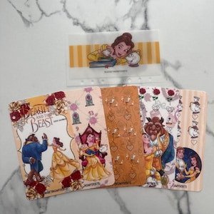 May include: A set of Beauty and the Beast themed savings challenge inserts for a binder. The cards feature illustrations of Belle, the Beast, Chip, and Lumiere, with text including Beauty and the Beast, $500 Savings, and BUDGETINGMYDEBTS.