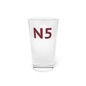 Op de afbeelding: Een helder pintglas met de bordeauxrode tekst "N5" en een witte afbeelding. Het glas is leeg en staat op een wit oppervlak. De tekst staat in het midden van het glas.